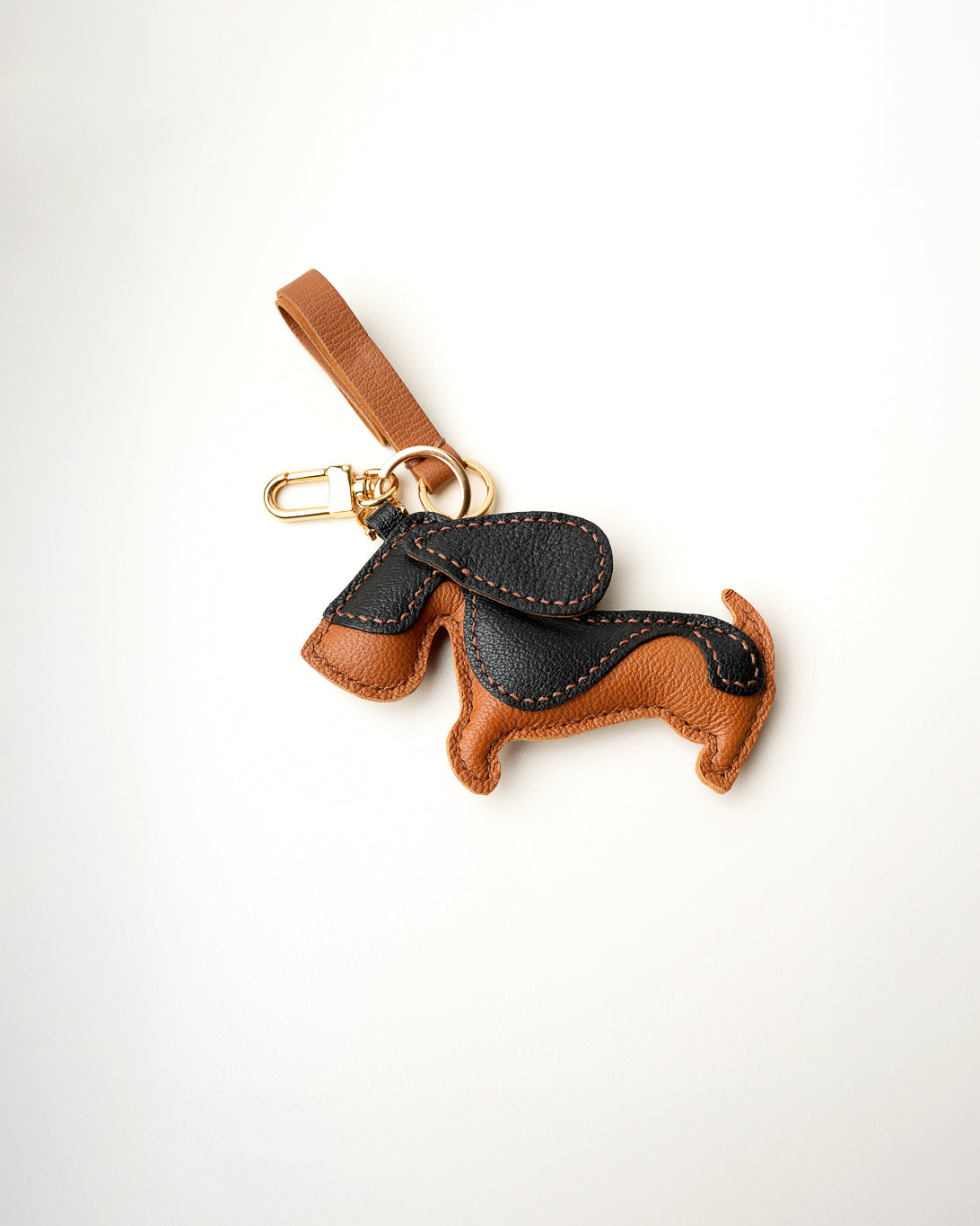 Mochi Manner handmade full-grain leather – sheep skin dachshund bag charm in tan and black with gold-plated hardware.