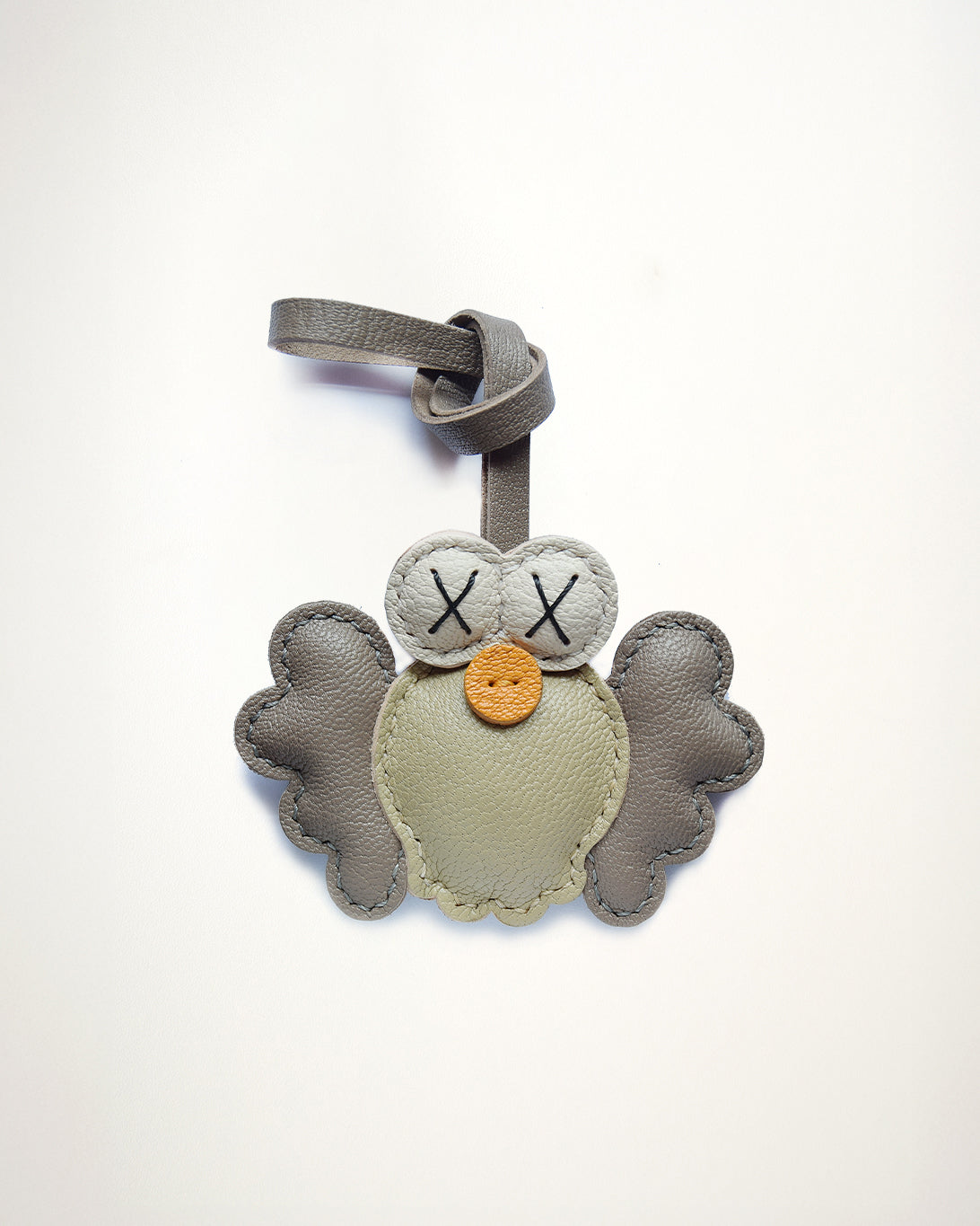 Mochi Manner handmade full-grain sheep leather owl bag charm in grey, taupe, and mustard with stitched details