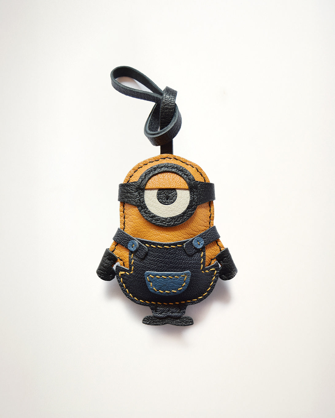 Mochi Manner handmade full-grain sheep leather Minion bag charm in yellow, black, and blue with hand-stitched details