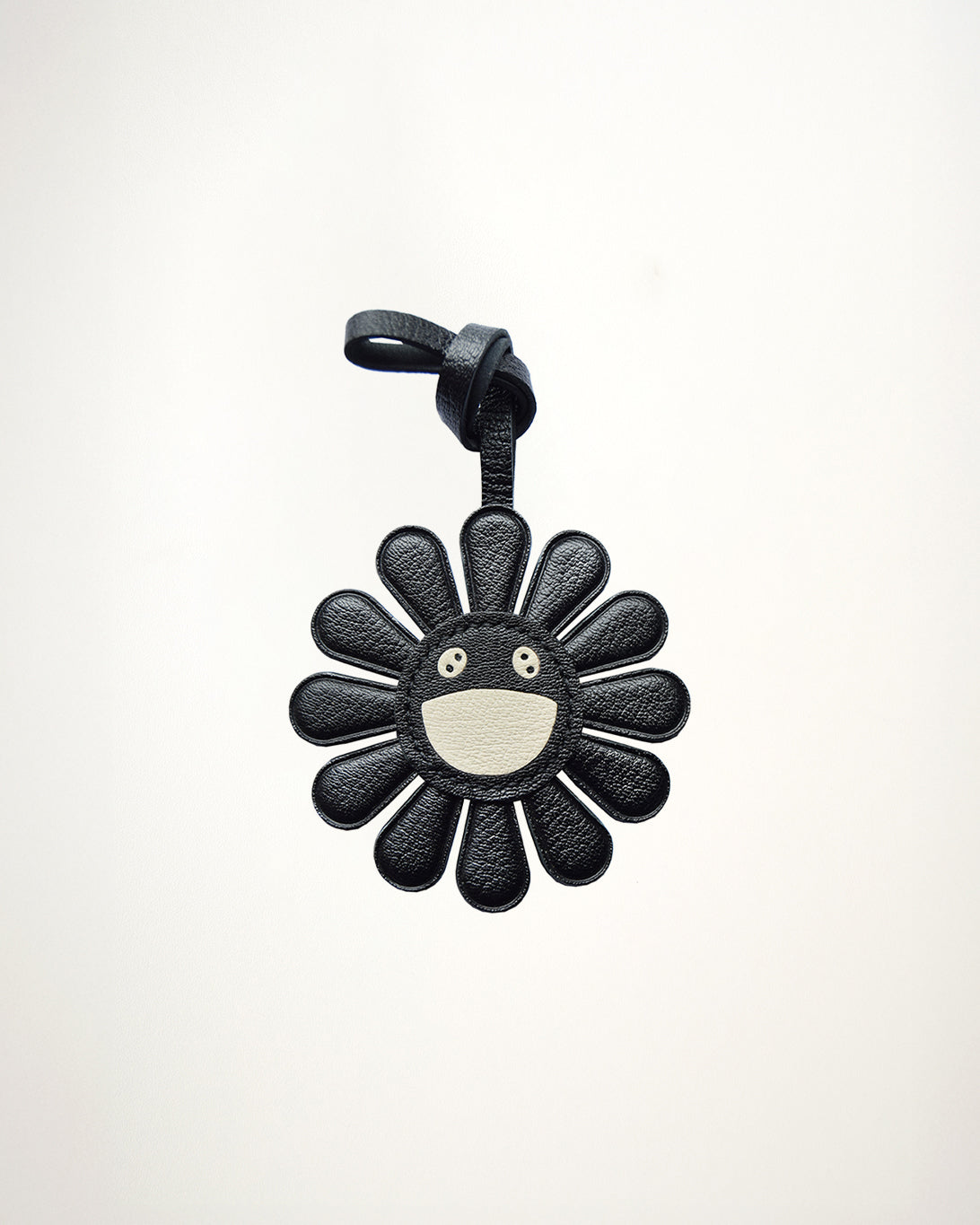 Mochi Manner handmade full-grain sheep leather black daisy bag charm with cream smiley face center
