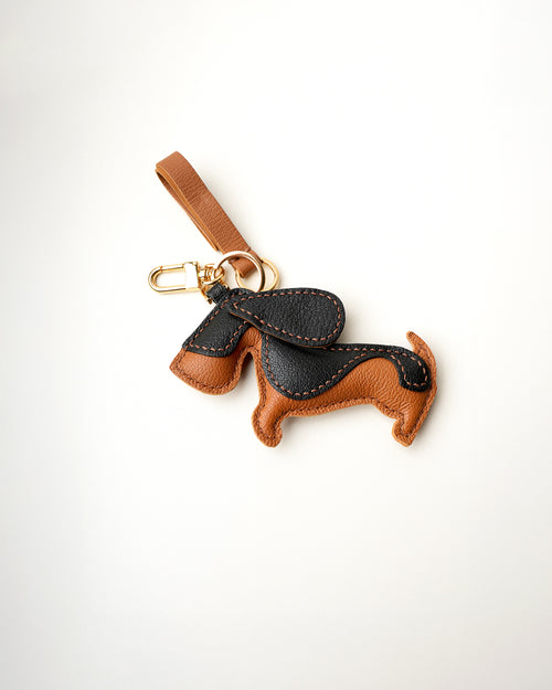 Mochi Manner handmade full-grain leather – sheep skin dachshund bag charm in tan and black with gold-plated hardware.